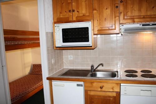 une cuisine avec un évier et un micro-ondes dans l'établissement Résidence Home Club 1 - Plusieurs studios disponibles pour vos séjours en famille ou entre amis MAE-3788, à Tignes