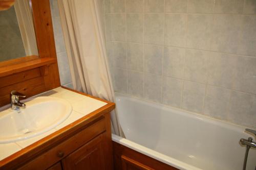 La salle de bains est pourvue d'un lavabo et d'une baignoire blanche. dans l'établissement Résidence Home Club 1 - Plusieurs studios disponibles pour vos séjours en famille ou entre amis MAE-3788, à Tignes