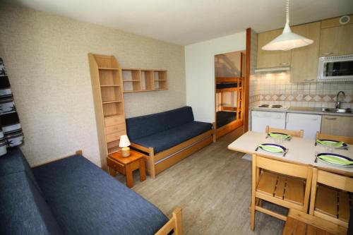 un salon avec un canapé bleu et une cuisine dans l'établissement Résidence Home Club 2 - Studio soigné et confortable MAE-3784, à Tignes