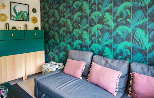 a living room with a blue couch and a green wallpaper at Nice Home In Gniewino With Kitchen in Gniewino