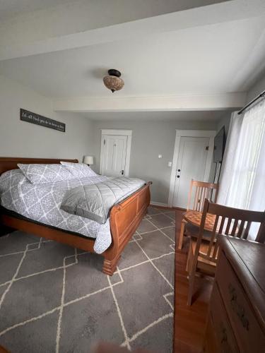 a bedroom with a bed and two wooden chairs at Hudson House Bed and Breakfast in Wheatland