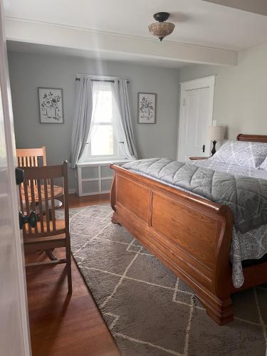 a bedroom with a bed and a chair and a window at Hudson House Bed and Breakfast in Wheatland