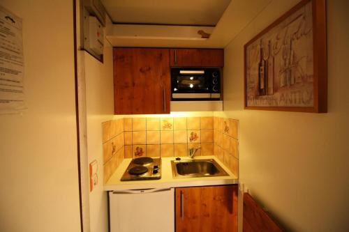 une petite cuisine avec un évier et un micro-ondes dans l'établissement Résidence Palafour - Petit studio 2 - nord vue montagne MAE-3798, à Tignes