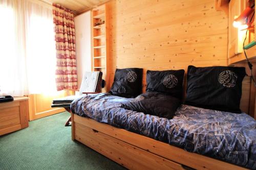 un lit dans une chambre avec un mur en bois dans l'établissement Résidence Tufs - Nid douillet pour 2, charmant et confortable studio MAE-3814, à Tignes