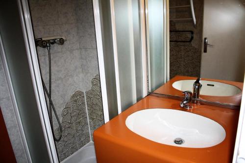 La salle de bains est pourvue d'un lavabo orange et d'une douche. dans l'établissement Résidence Palafour - Petit studio 2 nord - vue montagne MAE-3808, à Tignes