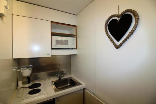 une petite cuisine avec un cœur accroché au mur dans l'établissement Résidence Palafour - Petit studio 2 - nord vue montagne MAE-3819, à Tignes