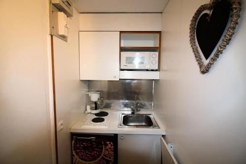 une petite cuisine avec un évier et un micro-ondes dans l'établissement Résidence Palafour - Petit studio 2 - nord vue montagne MAE-3819, à Tignes