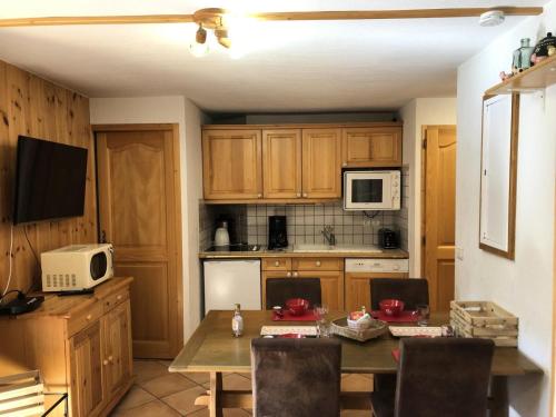 - une cuisine avec une table et un four micro-ondes dans l'établissement Résidence Le Krystor - Appartement 2 pièces cabine pour 4 personnes proche du centre de Méribel et des commerces MAE-4520, à Les Allues
