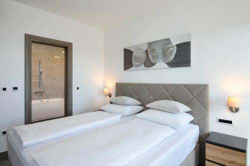 a bedroom with a large white bed with white pillows at Vila MI in Orebić
