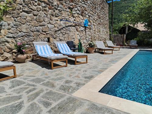 a group of lounge chairs next to a swimming pool at Mes Maisons Gardoises, Two Gites sleeping 13 with Two Private pools, Kids Room, Laundry, Disco, free WiFi, Linen and Dog's are Welcome in Gagnières