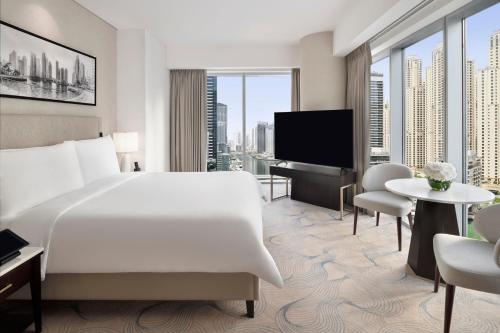 a hotel room with a bed and a flat screen tv at JW Marriott Hotel Marina in Dubai