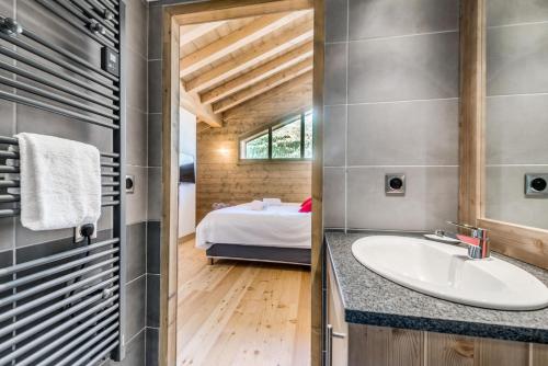 La salle de bains est pourvue d'un lavabo et d'un lit dans la chambre. dans l'établissement Résidence Lodge Des Neiges C - Appartement 4 - pied de pistes, service hotelier inclus MAE-2566, à Tignes