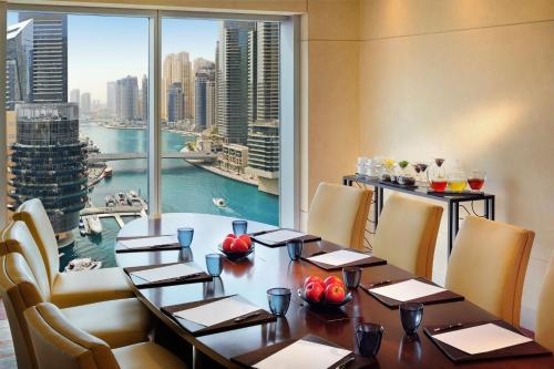 a dining room with a table and a large window at JW Marriott Hotel Marina in Dubai