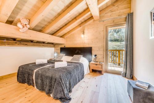 une chambre avec deux lits dans une pièce avec des plafonds en bois dans l'établissement Résidence Lodge Des Neiges C - Appartement 4 pied de pistes, service hotelier inclus MAE-2578, à Tignes