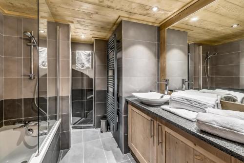 une salle de bain avec une baignoire, un lavabo et une douche dans l'établissement Résidence Lodge Des Neiges C - Appartement 4 pied de pistes, service hotelier inclus MAE-2578, à Tignes