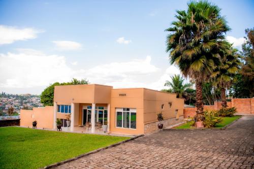 a house with a palm tree in front of it at Fleur Guest House in Kigali