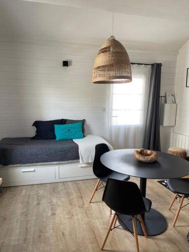 une chambre avec un lit, une table et des chaises dans l'établissement Mer et fougères, à Locmaria