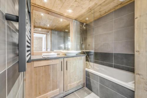 une salle de bain avec une baignoire et un lavabo et une baignoire dans l'établissement Résidence Lodge Des Neiges C - Appartement 4 - pied de pistes, service hotelier inclus MAE-2579, à Tignes