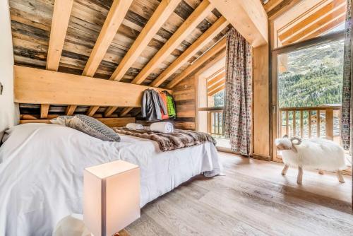 ティーニュにあるRésidence Lodge Des Neiges C - Appartement 4 pied de pistes, service hotelier inclus MAE-2581のベッドルーム1室(ベッド1台付)、窓の横に羊が立っています。