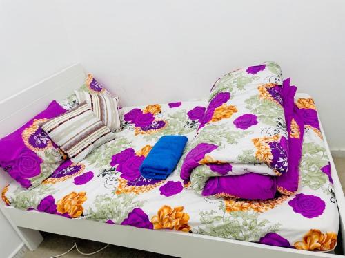 a bed with colorful blankets and pillows on it at BYC Homes in Abu Dhabi