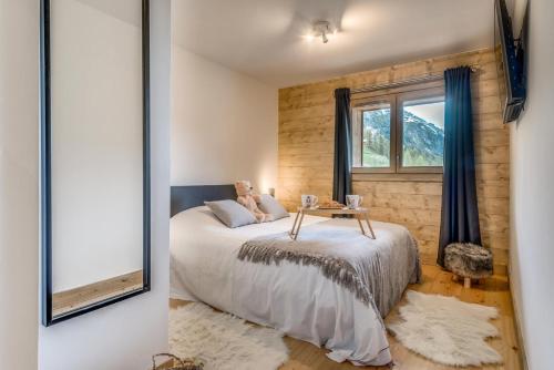 une chambre avec un lit et un miroir dans l'établissement Résidence Lodge Des Neiges C - Appartement 4 - pied de pistes, service hotelier inclus MAE-2583, à Tignes