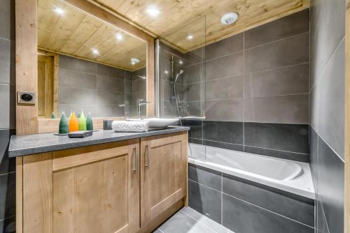 une salle de bain avec une baignoire et un lavabo dans l'établissement Résidence Lodge Des Neiges C - Appartement 4 - pied de pistes, service hotelier inclus MAE-4482, à Tignes