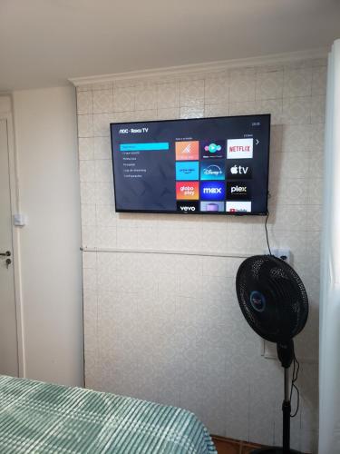 a flat screen tv on a wall with a fan at Pousada Monte Gerizim in Sao Paulo