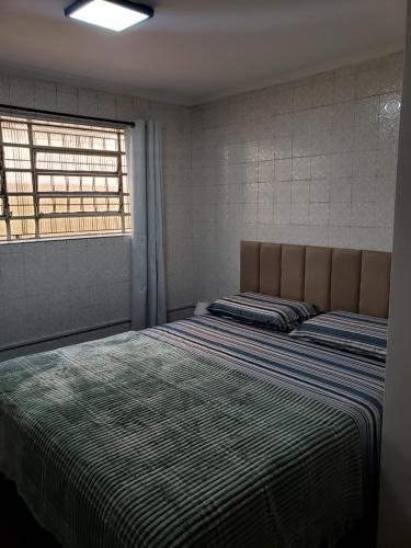 a bedroom with two beds and a window at Pousada Monte Gerizim in Sao Paulo