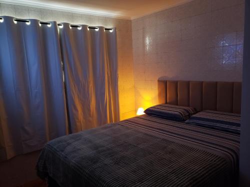 a bedroom with a bed with a blue curtain at Pousada Monte Gerizim in Sao Paulo