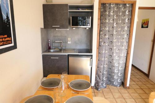 - une petite cuisine avec une table et des plaques de cuisson dans l'établissement Résidence Les Aiguilles - Bat Vorassay - Vorassay C35 MAE-5282, à Saint-Gervais-les-Bains