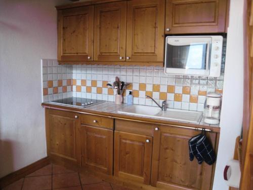 une cuisine avec un évier et un micro-ondes dans l'établissement Résidence Floralie - Domaine Des Lapons 2 - Lapons 2 Floralie 6 MAE-5337, aux Contamines-Montjoie