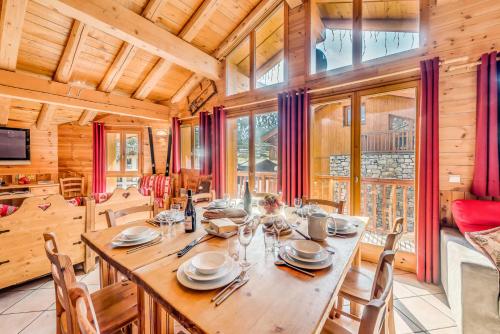 une salle à manger avec une grande table et des chaises en bois dans l'établissement Chalet Gypaete - Chalet Traditionnel 90m2 - 5 chambres, 4 salles de bain, sauna MAE-5891, à Tignes