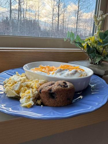 a plate of food with a muffin and a bowl of food at Bear Lake Lodgings B&B, Inc in Seward