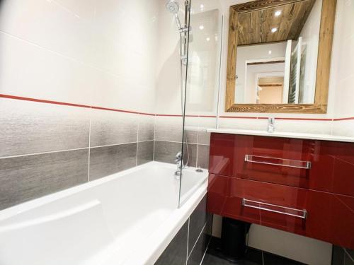 une salle de bain avec une baignoire et un miroir dans l'établissement Résidence Tommeuses - Studio rénové·Pieds des pistes ·Balcon MAE-6704, à Tignes