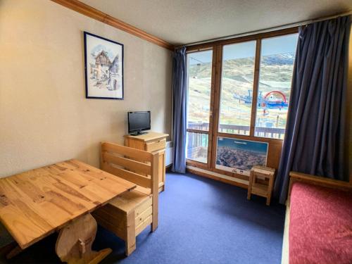 Cette chambre dispose d'une table en bois et d'une grande fenêtre. dans l'établissement Résidence Rond Point Des Pistes C - Studio·Proche des pistes·Balcon MAE-6804, à Tignes