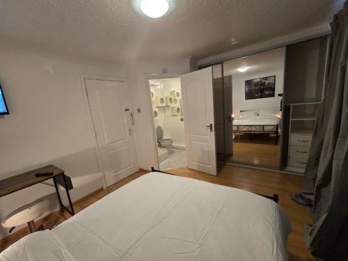 a bedroom with a white bed and a bathroom at MeadThames View in Thamesmead