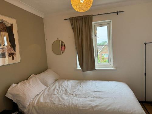 a bedroom with a white bed and a window at MeadThames View in Thamesmead
