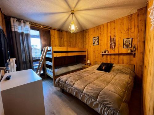 une chambre avec un lit dans une pièce aux murs en bois dans l'établissement Résidence Pramecou - 2 pièces confort à proximité des commerces MAE-6783, à Tignes
