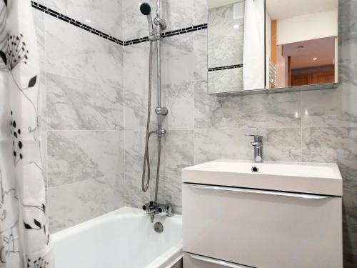 une salle de bain blanche avec un lavabo et une douche dans l'établissement Résidence Carroley A - 2 Pièces pour 4 Personnes 48, à Mâcot La Plagne