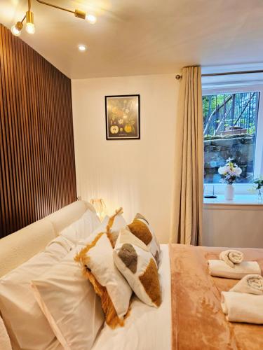 a bedroom with a bed with pillows and a window at River Haven Edinburgh in Edinburgh