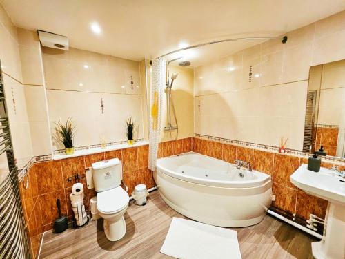 a bathroom with a tub and a toilet and a sink at River Haven Edinburgh in Edinburgh