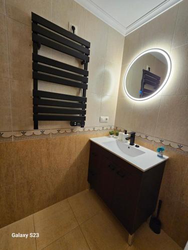 a bathroom with a sink and a mirror at Los Castelos by Urraca Suites Viveiro in Viveiro