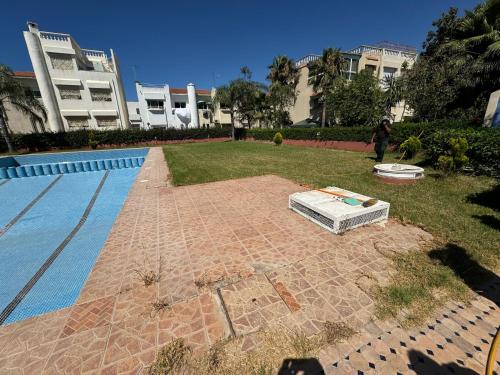 a bed sitting on the ground next to a swimming pool at Triplex à 5 min de la plage ! in Temara