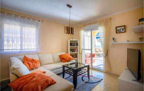 a living room with a white couch and a tv at Amazing Home In Puerto De Mazarrón in Puerto de Mazarrón