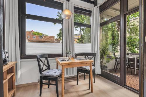 a dining room with a table and chairs and a window at HIRSCH Stadt Apartment 3 - Balkon mit Flussblick - Parkplatz in Bad Harzburg