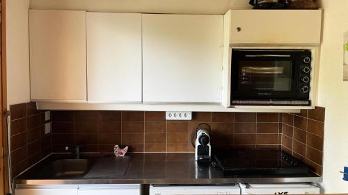 une cuisine avec un évier et un micro-ondes dans l'établissement Résidence Les Eperonnelles - Appartement 3 pièces pour 6 personnes situé à Méribel Altiport, proche des pistes de ski et du golf MAE-2644, à Les Allues