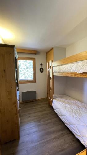 une chambre avec deux lits superposés et une fenêtre dans l'établissement Résidence Les Eperonnelles - Appartement 3 pièces pour 6 personnes situé à Méribel Altiport, proche des pistes de ski et du golf MAE-2644, à Les Allues