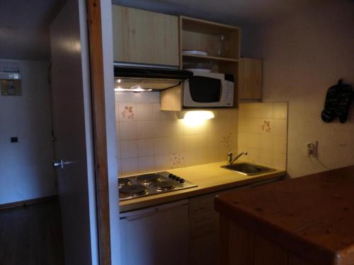 une petite cuisine avec un évier et un micro-ondes dans l'établissement Résidence L'ermitage - Appartement 2 pièces pour 4 personnes situé à Méribel centre proche des commerces et des pistes de ski MAE-3004, à Les Allues