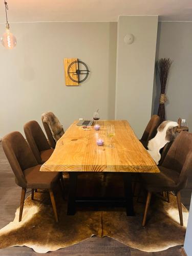 a wooden table with chairs and a dog sitting around it at Boris’s Guest Apartment in Chepelare