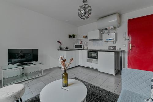 une cuisine avec un vase de fleurs sur une table dans l'établissement Sun94, à Fontenay-sous-Bois